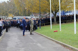 The Principal and students standing silently outside the academy building for Remembrance Day.