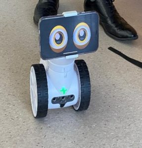 A robot moving across the floor, being controlled by a student.