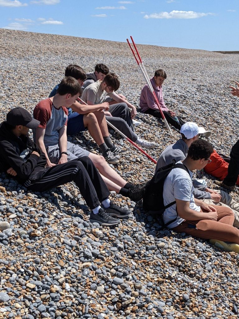Students sat on a beach