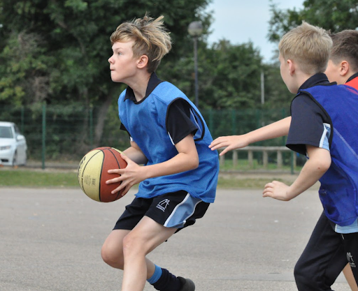 Students are seen playing Basketball together on Sports Day.