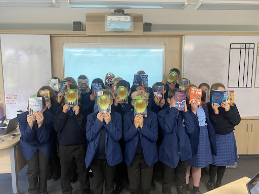 Students are seen holding up their reading books as part of the Book Buzz! programme.