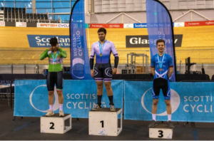 Year 13 student Will is seen standing as winner atop a podium for a junior Scottish Cycling Championship.