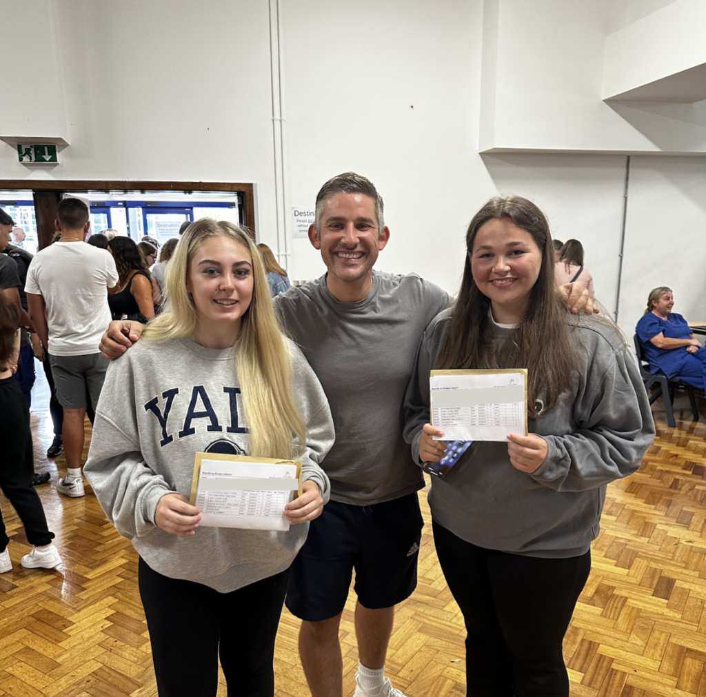 Students holding their results with a staff member