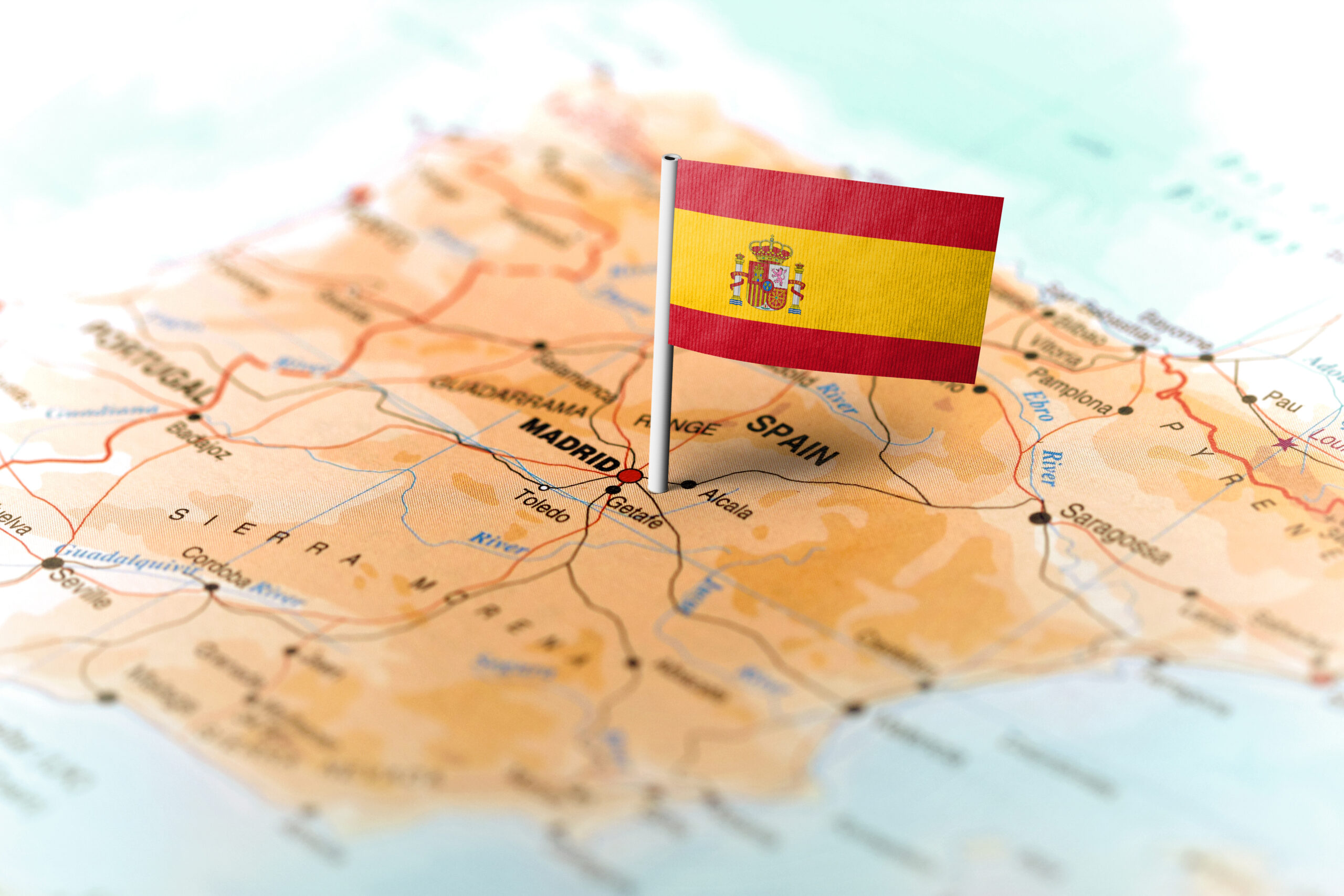 The flag of Spain pinned on the map. Horizontal orientation. Macro photography.